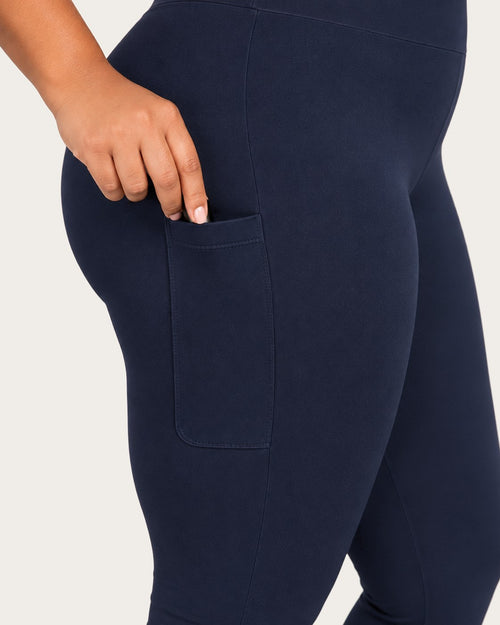 Close-up of a hand at the thigh pocket of midnight blue leggings