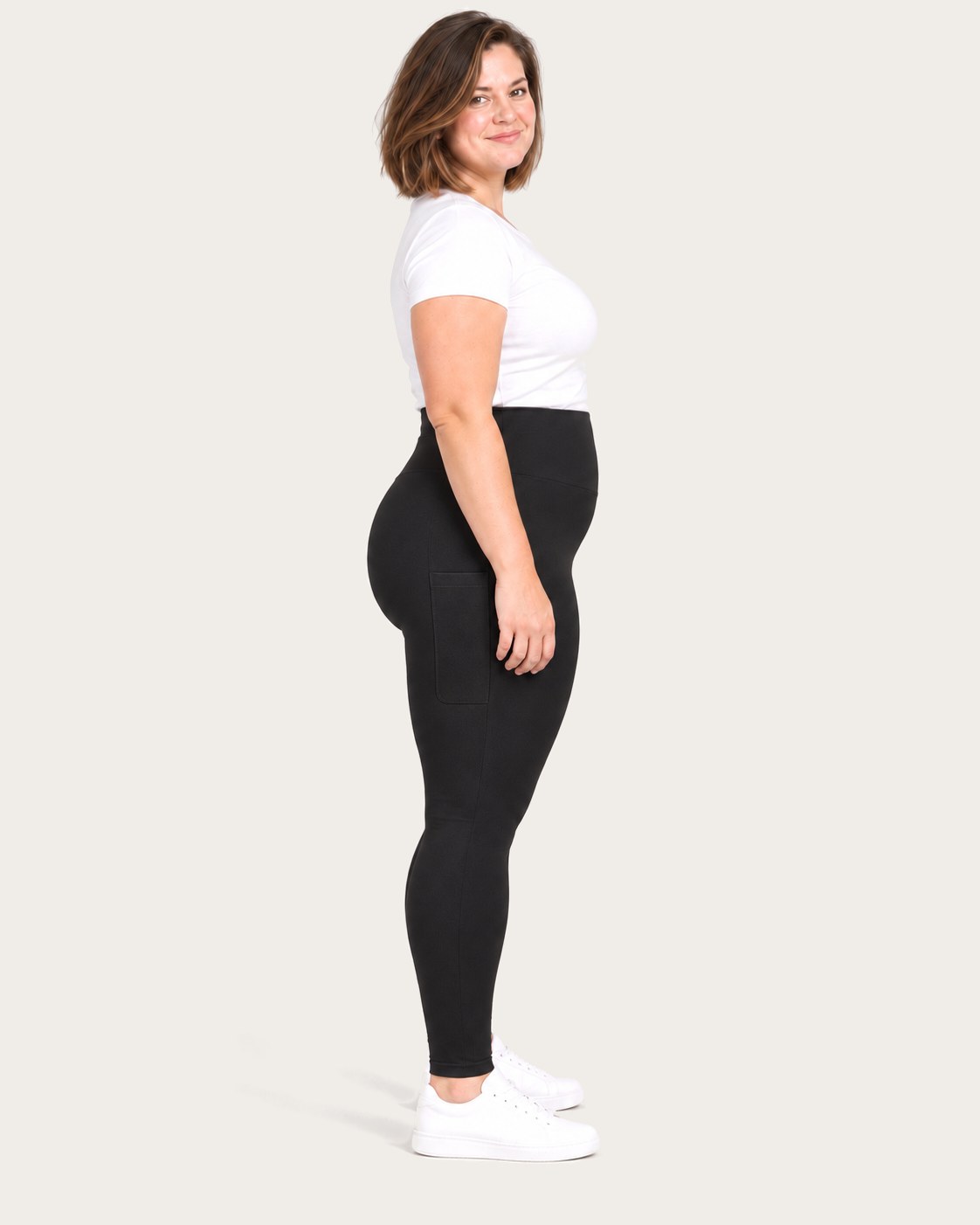 Mom in black postpartum leggings with side pockets, side view