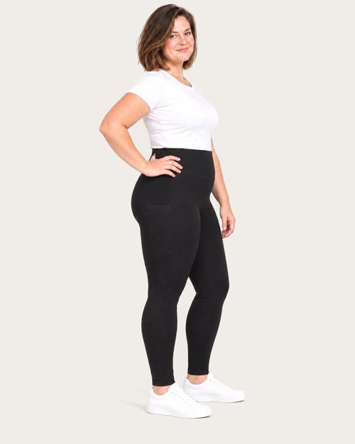 Mom in black postpartum leggings with side pockets, three-quarter view