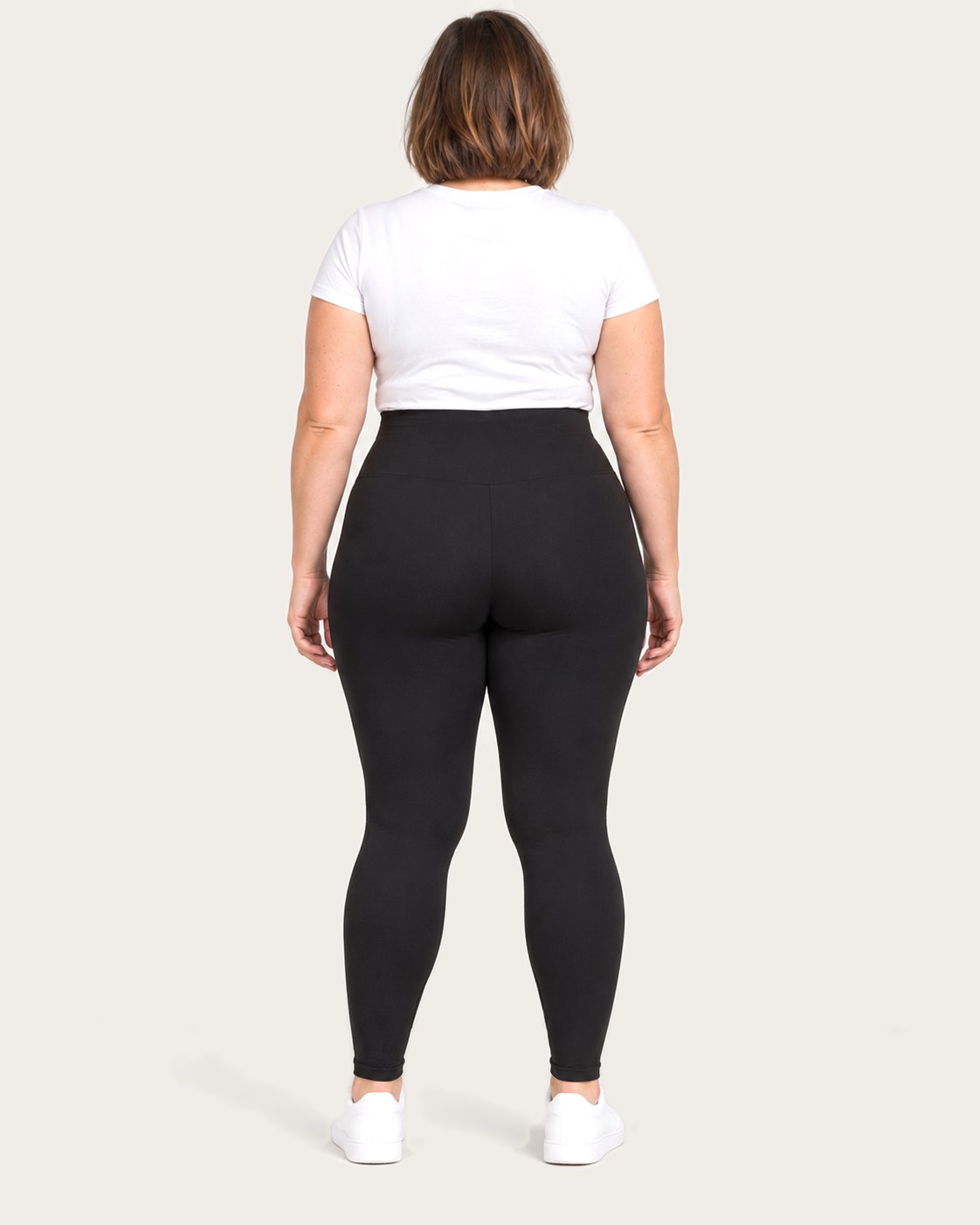 Mom in black postpartum leggings, back view